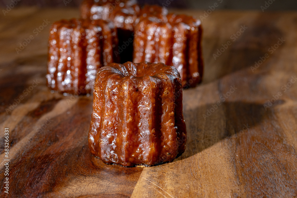 Canele, French pastry flavored with rum and vanilla, soft and tender custard center and dark, caramelized crust specialty of Bordeaux region, France Canele, French pastry flavored with rum and vanilla, soft and tender custard center and dark, caramelized crust specialty of Bordeaux region, France