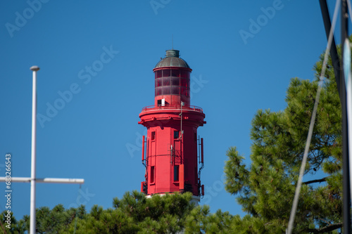 View on red lighthouse Le Phare du Cap Ferret, Arcachon Bay with many fisherman's boats and oysters farms near , Cap Ferret peninsula, France, southwest of Bordeaux, France's Atlantic coastline photo
