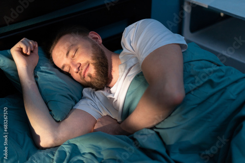 Top View of bearded happy man sleeping on comfortable bed in bedroom photo