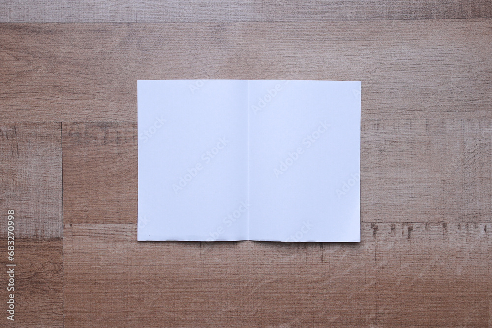 Blank white paper mockup on a wooden table
