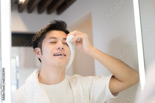 Man washing and refreshing his face Wiping his face with a towel