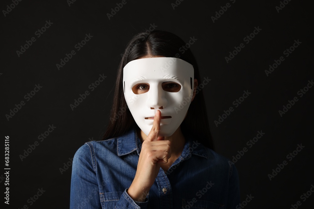 Multiple personality concept. Woman in mask on black background