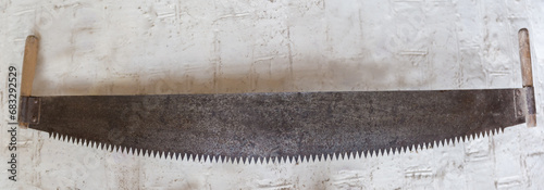 Old two-man crosscut saw against the white wall