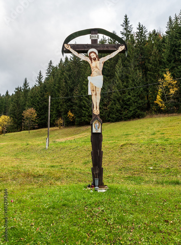 Wooden crucifix on meadow with forest on the background above Velke Karlovice village in Czech republic photo