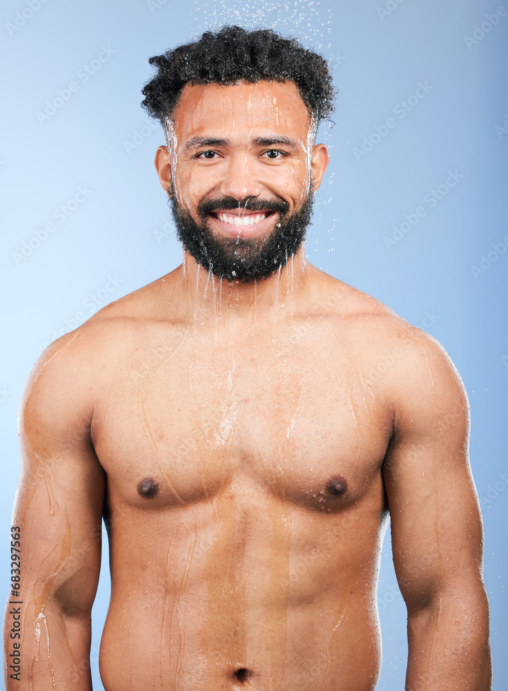Fototapeta premium Shower, cleaning and water with man portrait and smile from skincare and morning routine. Bathroom, cosmetics and male model in a studio with blue background and dermatology for wellness and wash