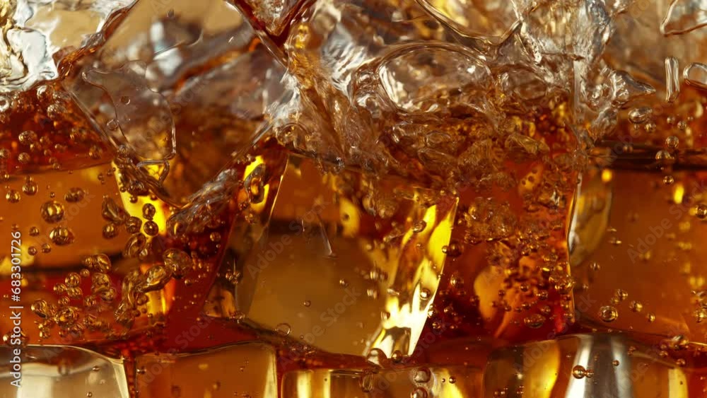 Super Slow Motion Detail Shot of Pouring Lemonade on Perfect Clear Ice Cubes at 1000fps.