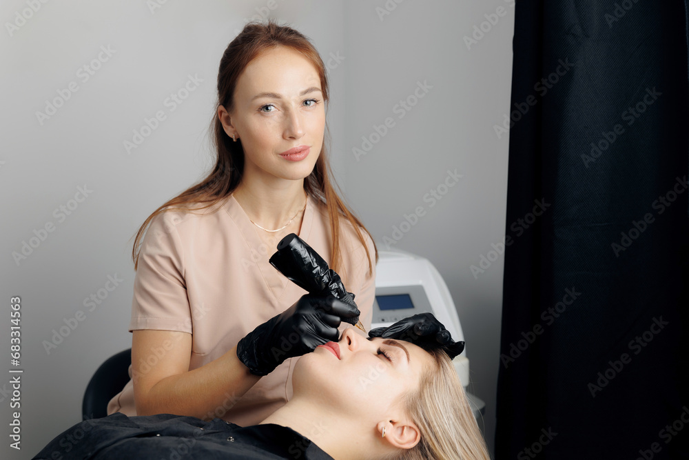 Procedure aesthetic for beautiful woman with black brows. Master use ink for permanent makeup tattoo for eyebrows in beauty salon