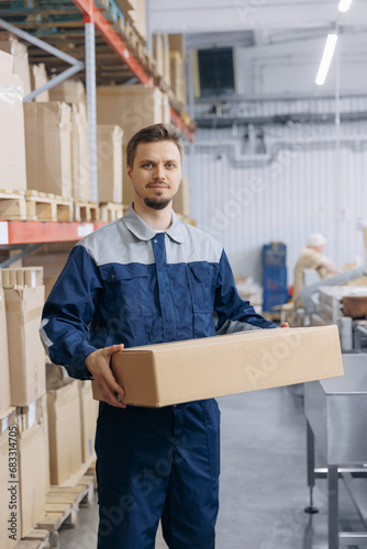 Portrait Man worker in warehouse storage hold cardboard box in hand. Concept logistic center for delivery