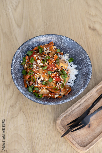 Bowl with tasty rice, meat and vegetables on wooden background top view, flat lay.