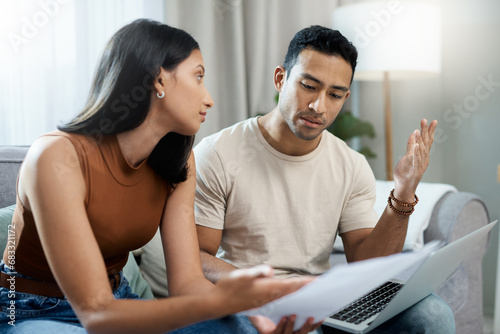 Frustrated couple, laptop and financial crisis in debt, mistake or argument on living room sofa at home. Man and woman with computer in disagreement for finance, mortgage expenses and bills at house photo