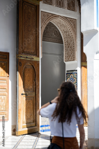 Obraz na płótnie Defocused girl in the foreground visiting the Bahia Palace during a sunny day. The Bahia Palace in Marrakech is an impressive example of Moroccan architecture and design. w salonie