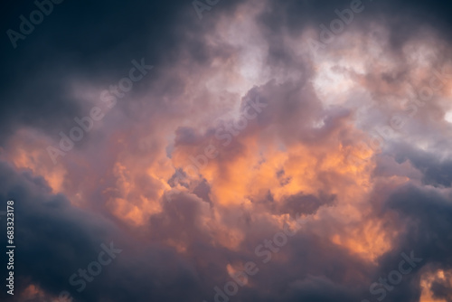 Epic sky at sunset. Dark dramatic sky clouds with orange sunlight holes. Storm weather. Beauty in nature. Twilight, golden hour. Thunderstorm. Evening sunset. Nature landscape. Panoramic view