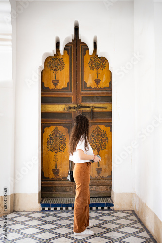 Obraz na płótnie Stunning view of a girl visiting the Bahia Palace during a sunny day. The Bahia Palace in Marrakech is an impressive example of Moroccan architecture and design. w salonie
