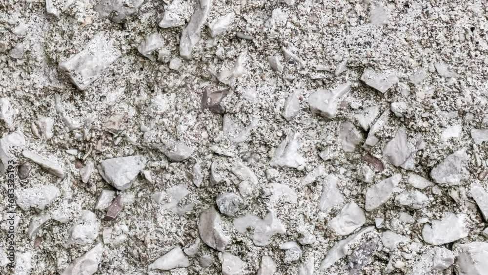 Crushed stone embedded in cement mortar, rough surface, background rotating, turning, close-up macro, top view Crushed stone embedded in cement mortar, rough surface, background rotating, turning, close-up macro, top view