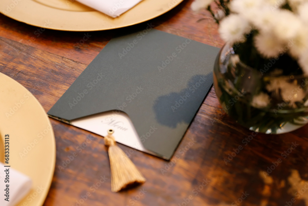 stylish menu in dark envelope on wooden table