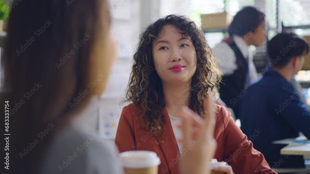 Happy colleagues tow Asian business woman having a coffee break in an office Happy colleagues tow Asian business woman having a coffee break in an office