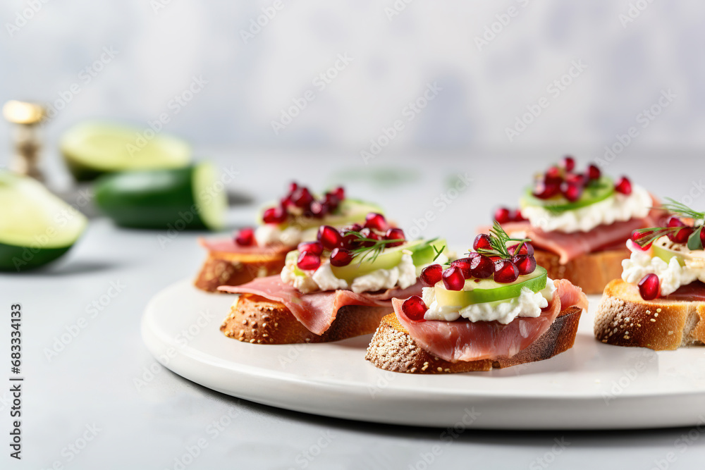 Canape with pomegranate and salami on light background Canape with pomegranate and salami on light background