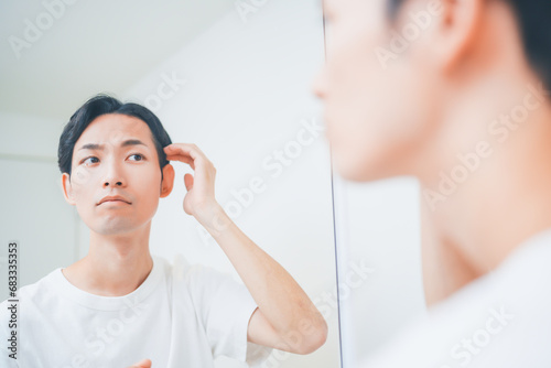 洗面所でヘアセットをする男性