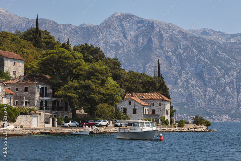 Perast, Montenegro, with its timeless architecture against a backdrop of towering mountains, as seen from the waterfront.