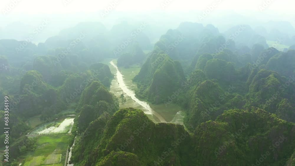 Drone, landscape and river in mountains with fog in the sky of jungle, nature and environment in Vietnam. Green, hills and clouds on horizon in tropical forest, countryside or growth of bush in woods Drone, landscape and river in mountains with fog in the sky of jungle, nature and environment in Vietnam. Green, hills and clouds on horizon in tropical forest, countryside or growth of bush in woods