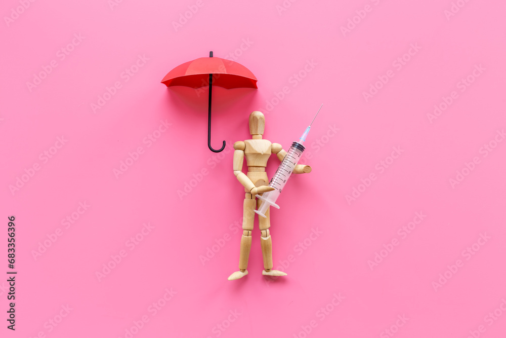 Wooden figurine of a man with syringe and vaccine. Medicine and healthcare concept