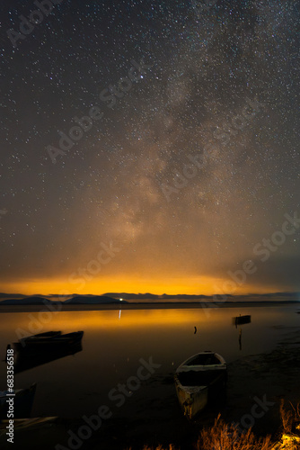 Old fishing boats on the albanian lagoon at night. Starry sky whith milkyway