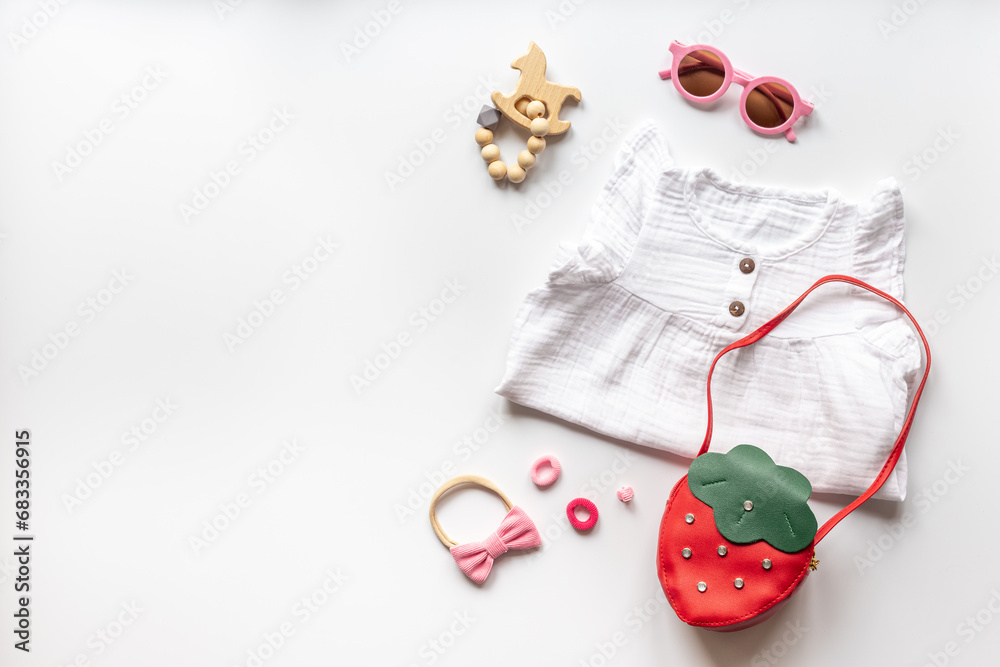 Stylish white baby dress with sunglasses and accessories, top view Stylish white baby dress with sunglasses and accessories, top view