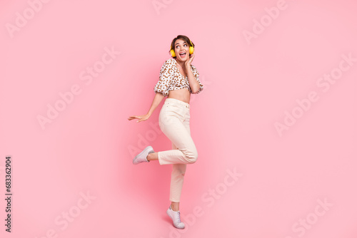 Full size photo of impressed ecstatic girl dressed stylish blouse touch headphones look empty space isolated on pink color background