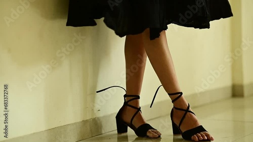 Elegant lady legs in black shoes. black skirt. Legs moving. Dancing pose