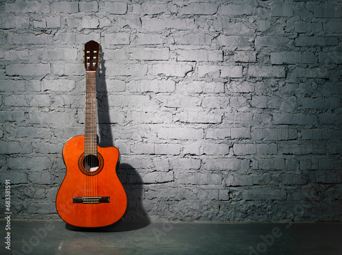 Acoustic guitar leaning on grungy wall © Dasha Petrenko