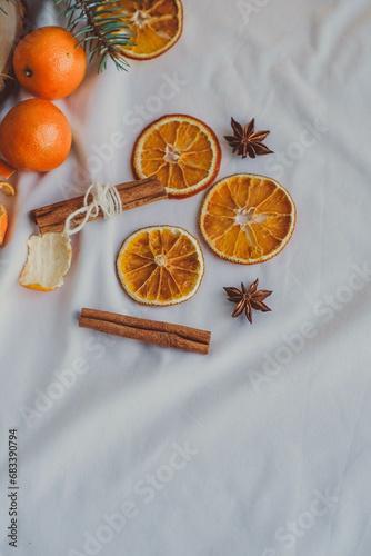 Dried orange slices with cinnamon sticks and star anise on a white background