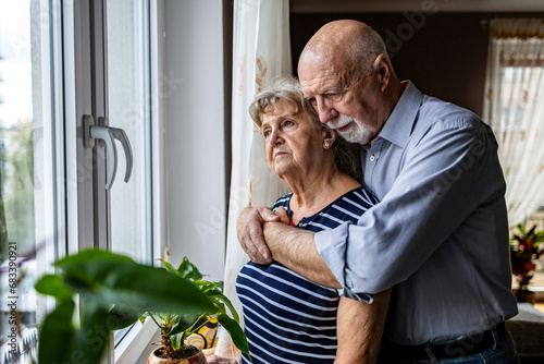 Portrait of senior couple looking out the window at home
 photo