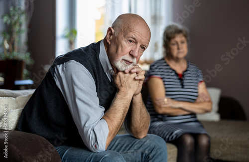 Senior couple sitting on sofa at home having a relationship problems
 photo
