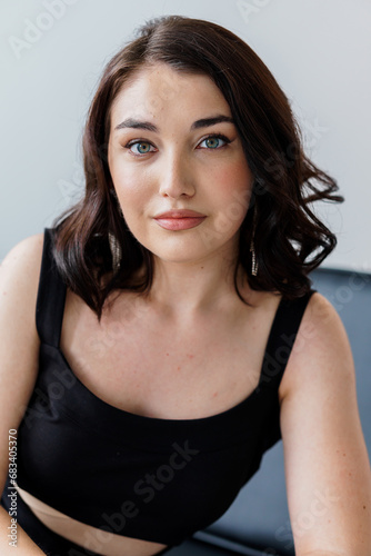 Portrait of a young beautiful girl in a black dress on a white background