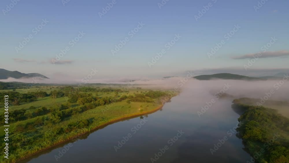Morning light on low fog and mist over river in green natural landscape Morning light on low fog and mist over river in green natural landscape