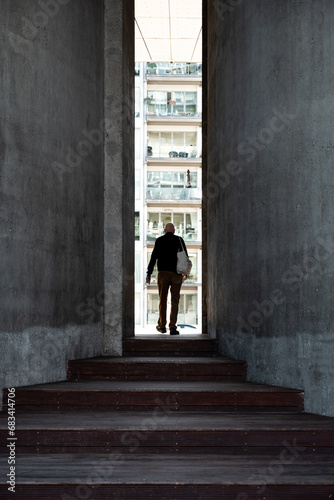 person walking between concrete columns
