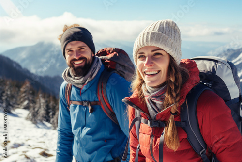 Portrait of a happy man and woman traveling through the mountains with backpacks in winter. Hiking