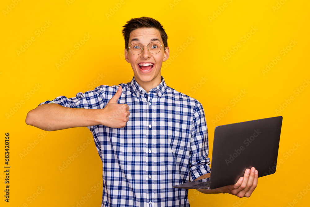 A man holds a laptop in his hands while standing, working on a PC, typing on a keyboard showing thumb up A man holds a laptop in his hands while standing, working on a PC, typing on a keyboard showing thumb up