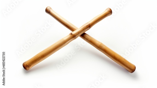 A pair of classic drumsticks, crossed over each other, conveying rhythm and beat, positioned on a white surface.