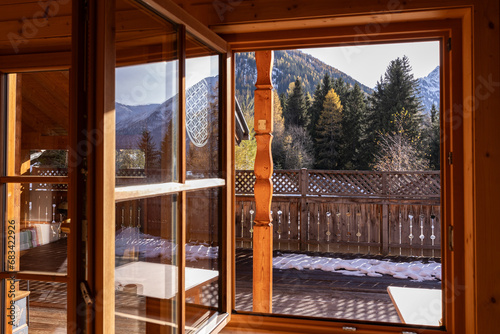 View of a sun-drenched terrace overlooking mountains and autumn conifers, Austria
