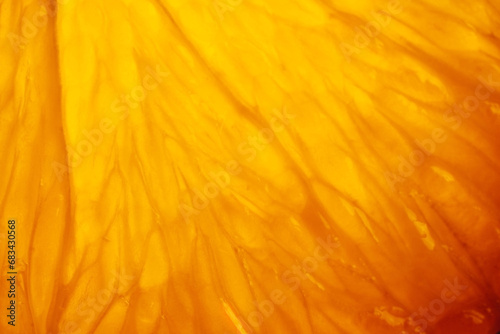 Orange slice with backlight, abstract macro photography orange fruit closeup background, citrus fruit texture photo