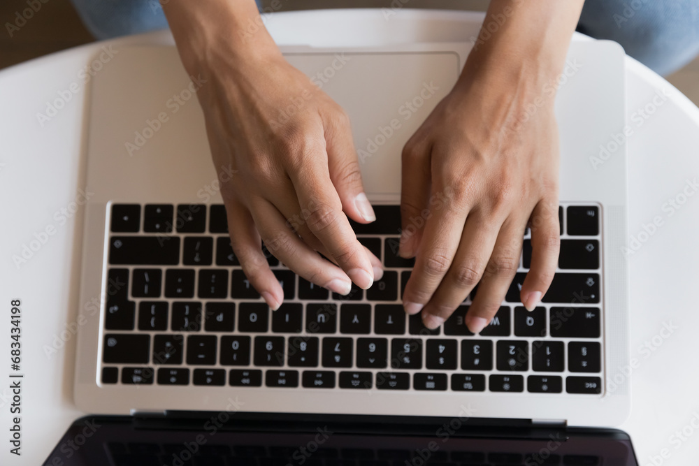Top view unknown female hands typing on laptop keyboard. Businesswoman contact to client by e-mail, makes order through ecommerce services, buying goods on-line. Freelance, blogging, telework concept Top view unknown female hands typing on laptop keyboard. Businesswoman contact to client by e-mail, makes order through ecommerce services, buying goods on-line. Freelance, blogging, telework concept