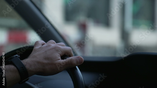 Focused Drive, Close-Up of Hand Gripping Vehicle Steering Wheel on Road