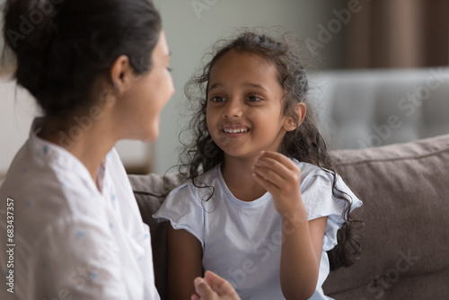 Cute stuttering Indian little girl engaged in class take part in pronunciation lesson with female speech therapist or caring mother, train articulation, repeat words correctly. Kid development concept
