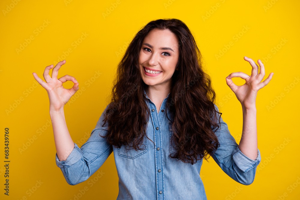 Photo of friendly pretty girl toothy smile arms fingers demonstrate okey symbol isolated on yellow color background Photo of friendly pretty girl toothy smile arms fingers demonstrate okey symbol isolated on yellow color background