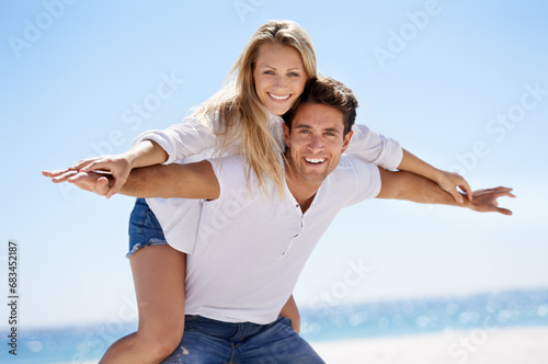 Couple, beach and happy for piggy back in portrait, vacation or freedom in summer sunshine for bonding. Man, woman and plane game with smile, care or love by sand, waves or play on holiday in Napoli