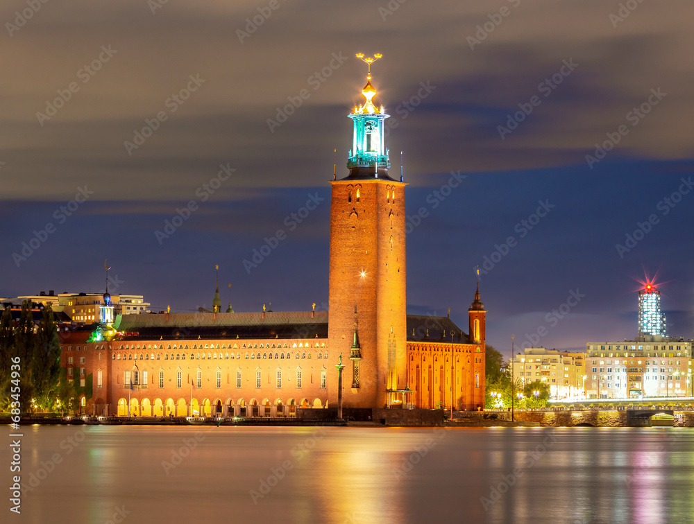 The building of the stone Stockholm City Hall on the shore of the strait.