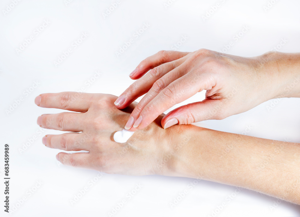 Close-up of woman applying protective cream to her hands. Hand skin protection during the cold season, hand care