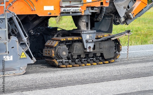 Close-up view of a track of an asphalt planer on a road