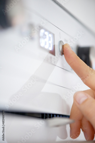 Closeup, finger and button on oven in kitchen for heating, preparation and appliance for baking. Person, press or switch with number display for setting, temperature and timer in home for cooking